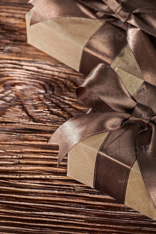 Brown present boxes with tied bow on vintage wooden board
