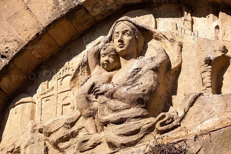 An old baroque engraved sculpture of Mary and Jesus over an entrance to the Cappella della Croce di Giorno in VolterraCappella della Croce di Giorno