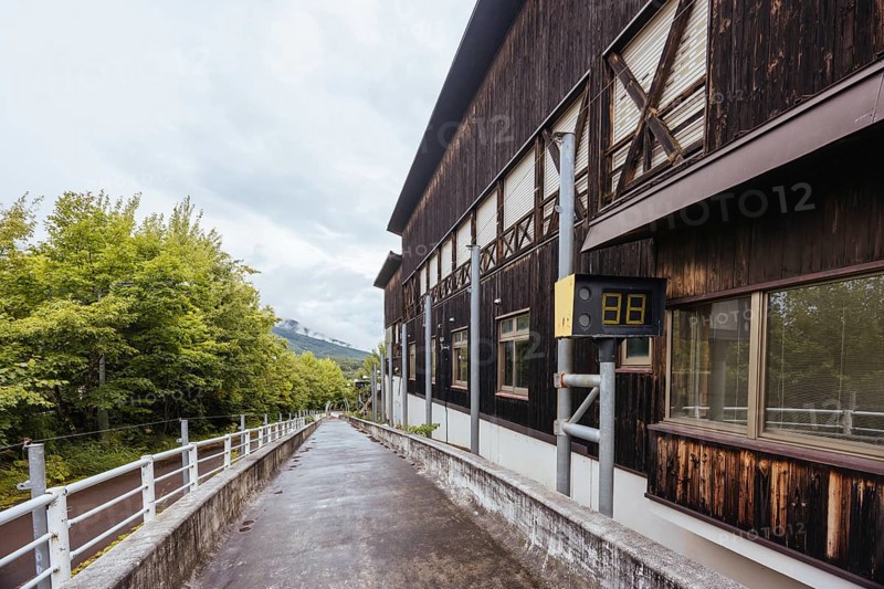 IIZUNA, JAPAN - SEPTEMBER 19, 2024: The now abandoned Nagano 1998 Olympic Spiral luge bobsleigh course on a wet autumn day in Iizuna village, near Nagano, Japan, Nagano, Japan