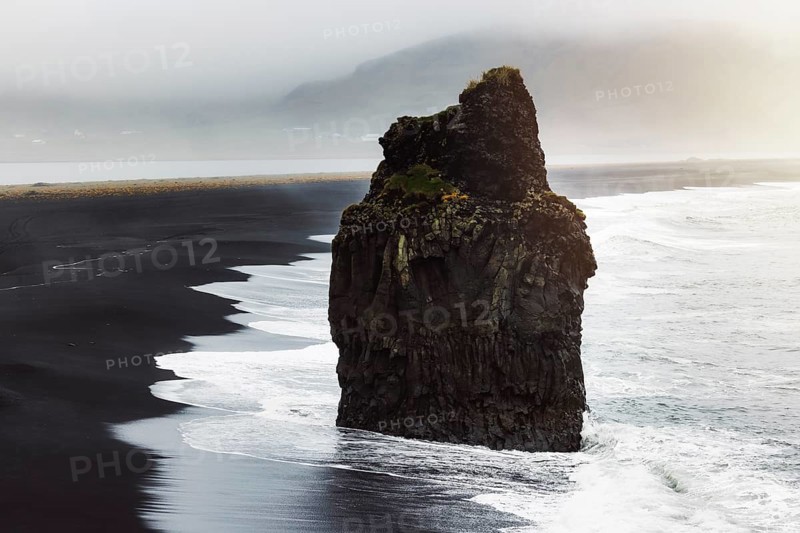 Detail of Arnardrangur rock in the middle of peninsula near Reynisfjara Beach view point Dyrholaey in overcast weather.