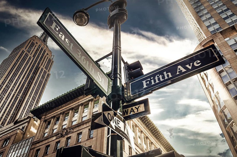 Fifth Ave 5th Ave, New York City sign, view from low angle with sunset and empire state building in thebackground, america, usa