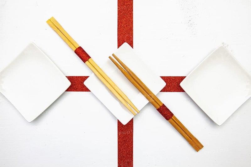 Ceramic bowls and bamboo chopsticks for sushi food with red and white decoration