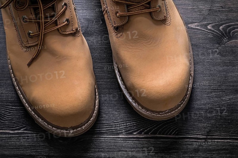 Safety working boots on wooden board construction concept