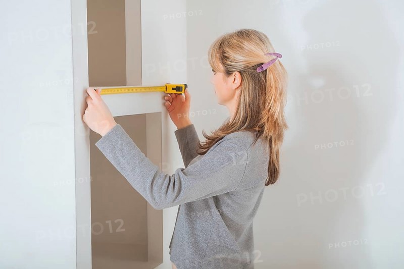 Female worker measuring with tape measure