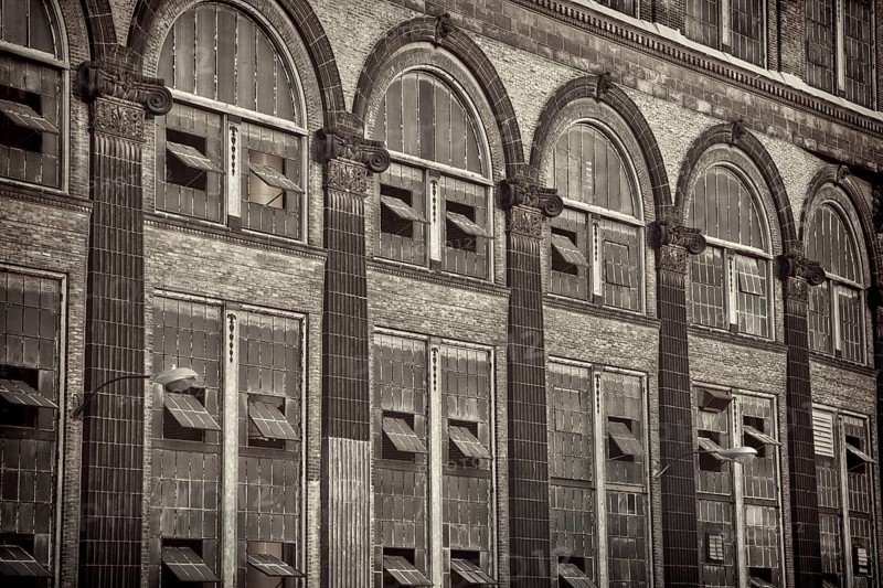 Old power plant - windows and brick walls with sandstone decoration, sepia toned black and white image