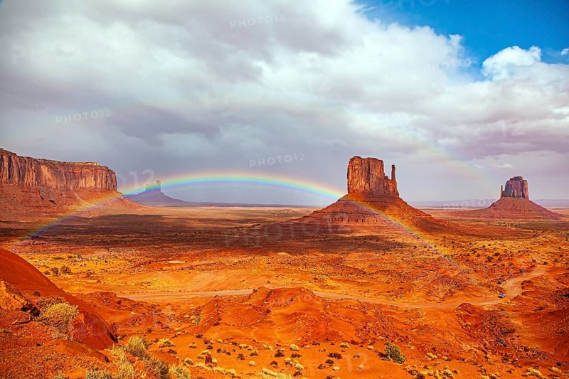 The bright rainbow all over the sky. Monument Valley is a unique geological formation in Arizona and Utah. The famous rock Mitten. USA. Navajo Indian Reservations