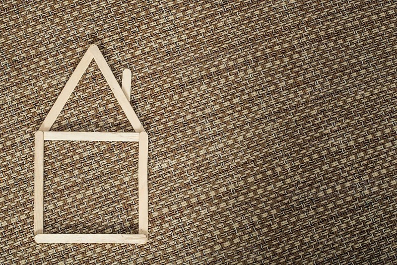 Model house made of wooden sticks placed in room interior
