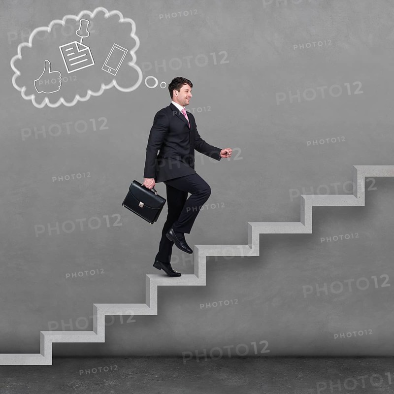 Image of confident businessman with briefcase walking upstairs