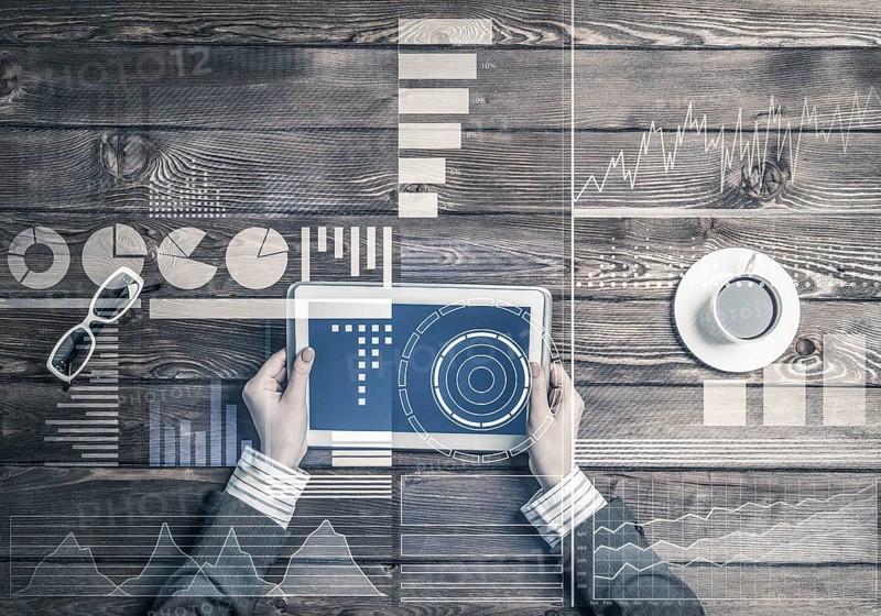 Business workplace with tablet device on wooden surface and media interface