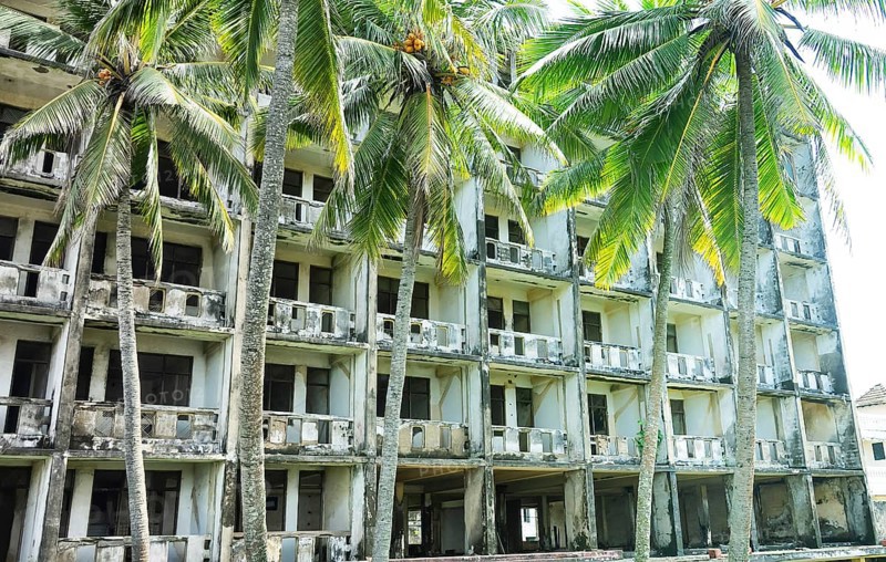 Abandoned hotel in coastal recreation area in Southeast Asia. Palm trees and failed otel business