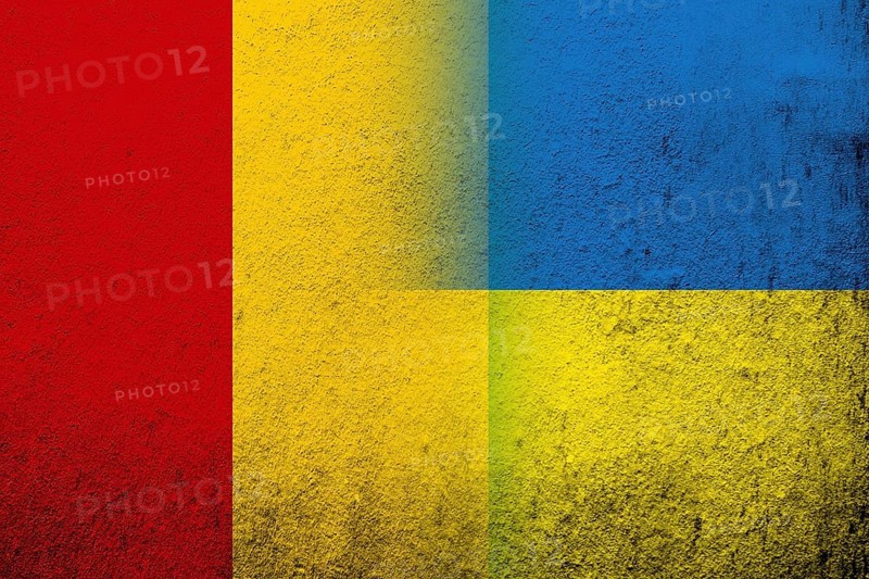 The Republic of Guinea National flag with National flag of Ukraine. Grunge background