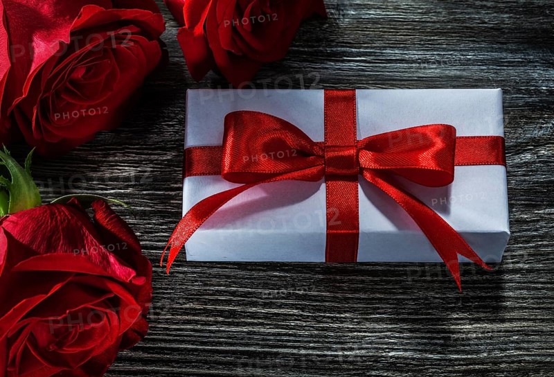 White present box natural red roses on wooden board