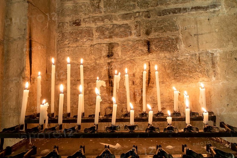 An image of some burning candles in a church in Italy