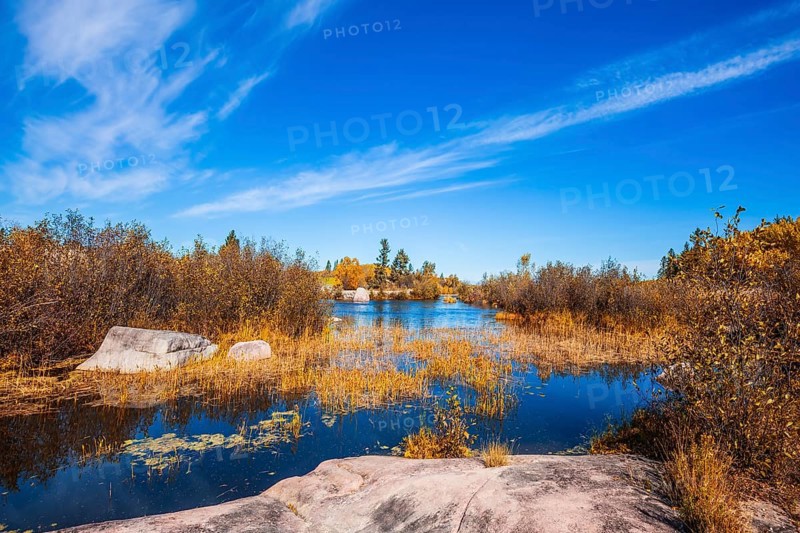 Old Pinawa Dam Provincial Heritage Park. Warm day. Yellow autumn grass is reflected in the Winnipeg River. The concept of ecological and recreational tourism