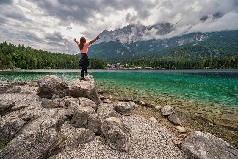 Zugspitze Peak top of Germany Alps mountain range and Eibsee Lake with woman tourist, Garmisch Partenkirchen Germany