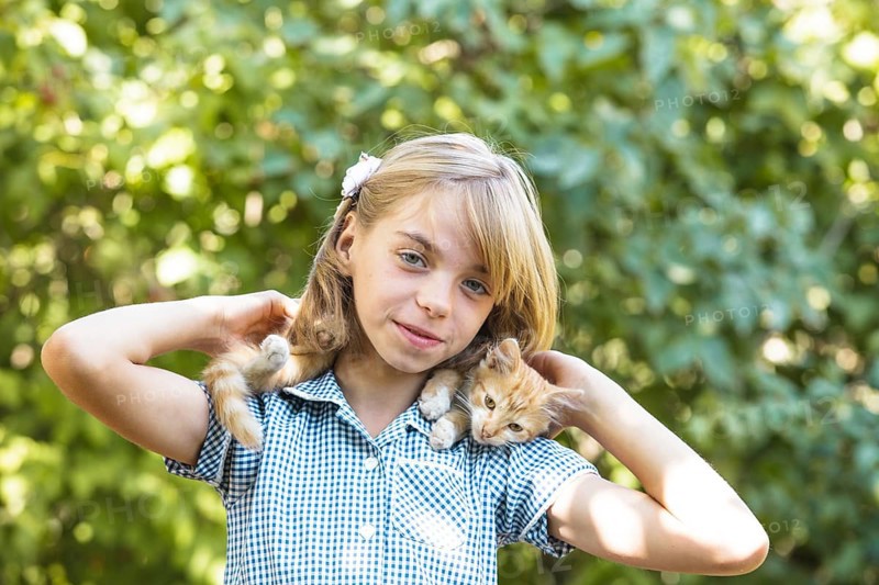 Girl play with kitten outdoor in the park