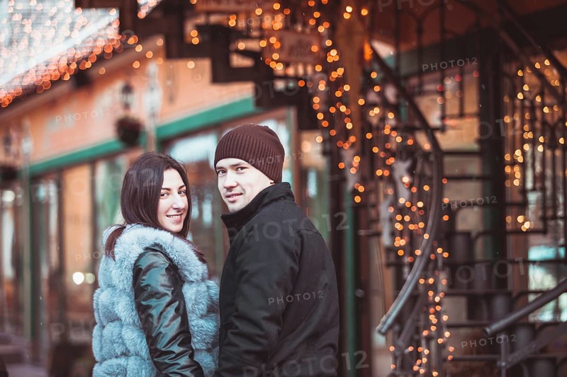 Romantic couple walking in the winter under the snow in Christmas time
