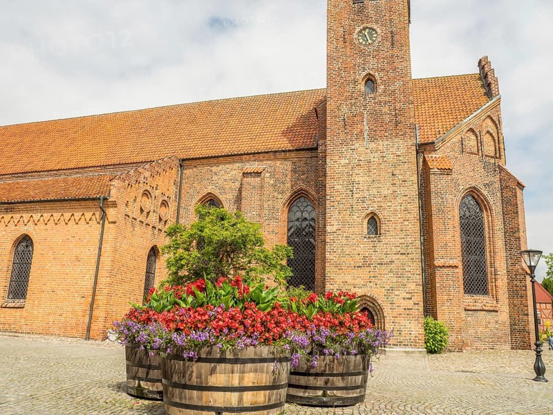 Church in the background with large flower pots in the foreground, historic brick walls, ystad, sweden, baltic sea, scandinavia