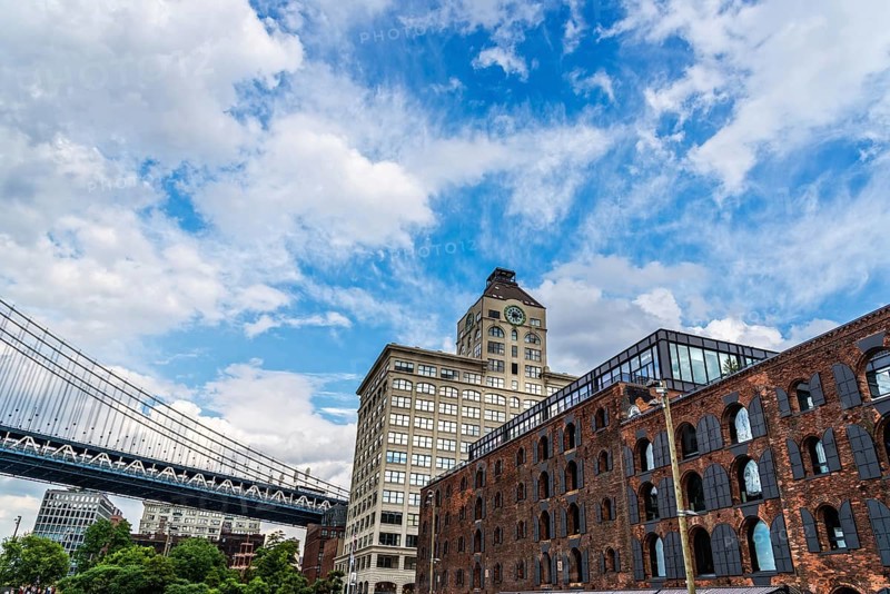 New York City, USA, June 24, 2018: Waterfront of DUMBO area in Brooklyn. Down Under the Manhattan Bridge Overpass. View Against Blue Sky during Summer