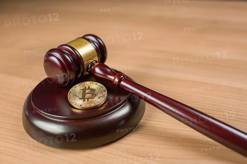 Bitcoin regulation. BTC cryptocurrency coin and judge gavel on a desk. Banned currency or law enforcement concept