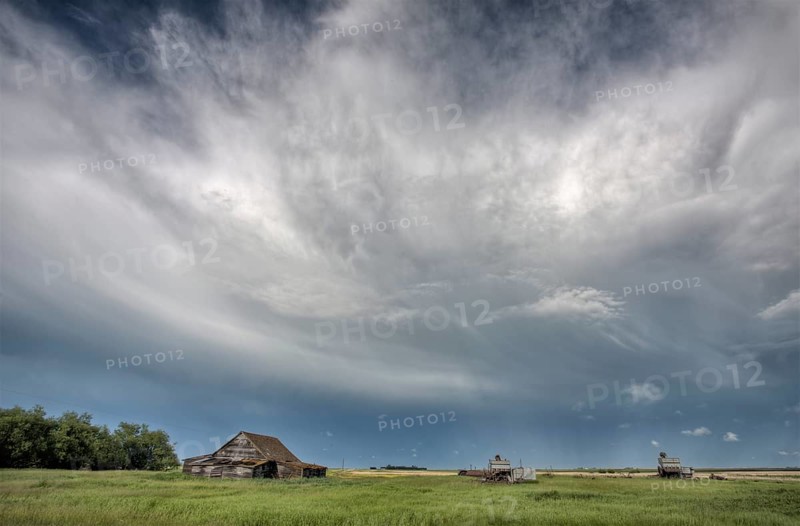 Abandoned Farm with storm clouds in the Canadian Prairie