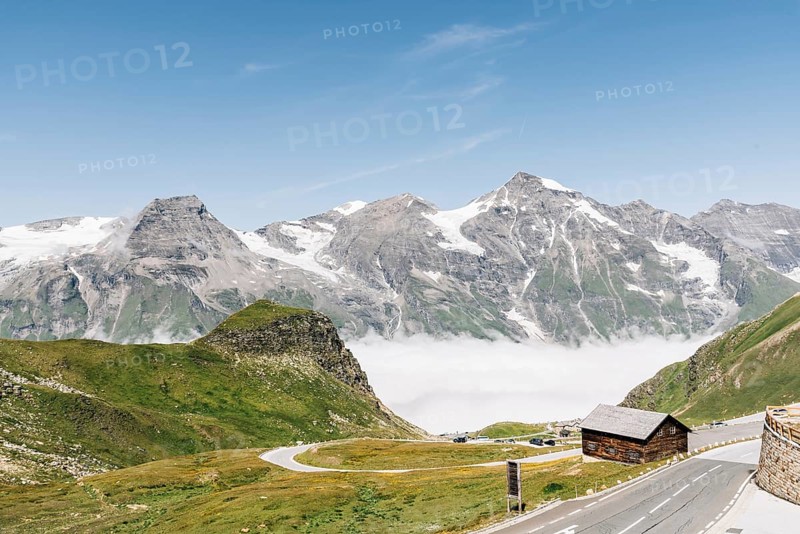 Scenic view of Alpine road through valley with sea of clouds. Grossglockner, Austria. Space for copy