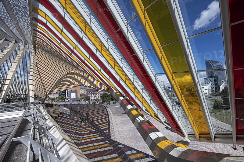 Colourful glass roof adorns the sides of a modern railway station with a view of the city, Liège, Wallonia region, Belgium