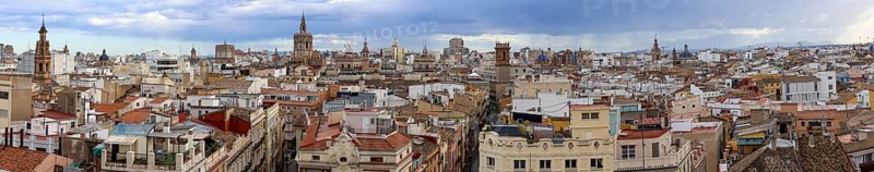 Panoramic photo of the rooftops of Valencia with the towers of the city's churches, as well as the tower and dome of the Gothic Cathedral of Valencia (Catedral de Santa María de Valencia), photographed from the top of the Serranos Towers (Torres dels Serrans) in the centre of the old town, Valencia, Valencian Community, province of Valencia, Spain
