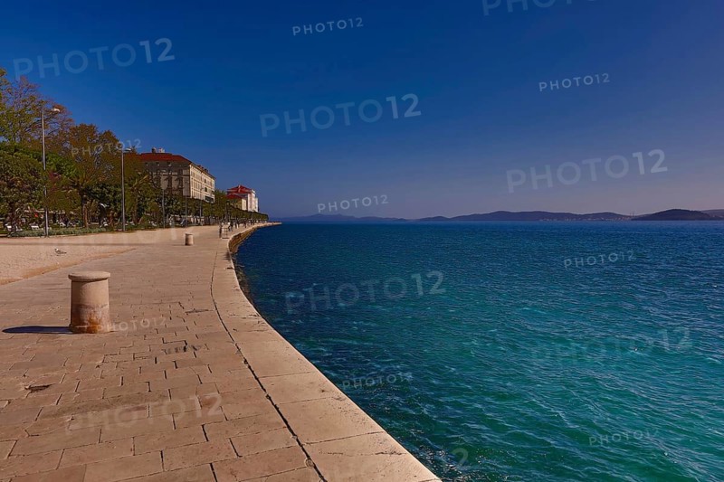 Long promenade along the blue water, with historic buildings and a clear sky in the background, Zadar Dalmatia Croatia