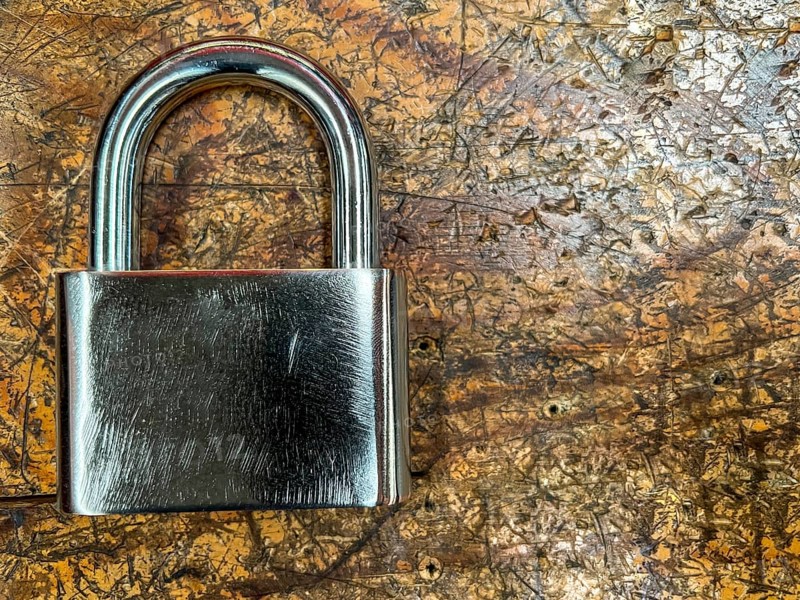 Metal padlock on a wooden background