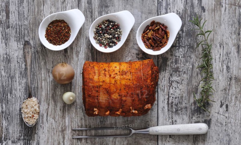 Stuffed pork belly with spices. Gammon meat with different spices on a wooden table