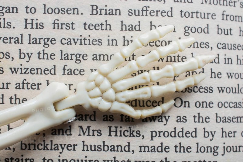 Skeletal hands book text. death, halloween and mistery concept