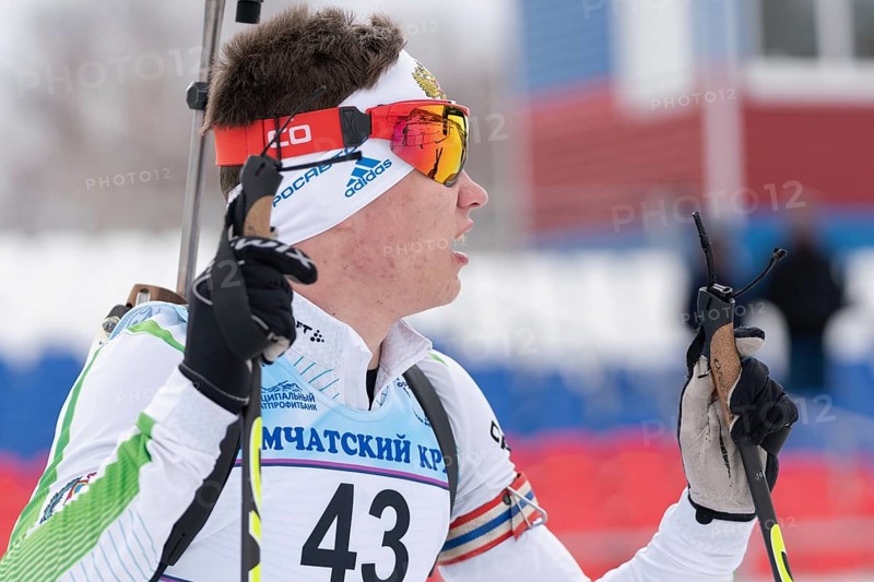 Portrait Russian sportsman biathlete Zlobin Vladislav Khanty-Mansiysk at finish after rifle shooting and skiing. Junior biathlon competitions East of Cup. Kamchatka, Russian Far East, April 12, 2019