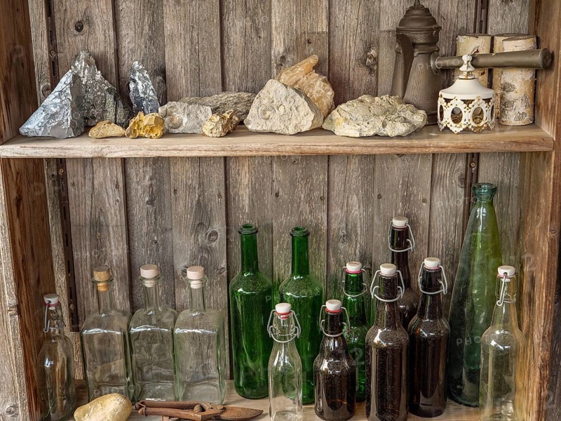 Shelves with bottles and stones on a rustic wooden wall, antique atmosphere, borken, münsterland, germany