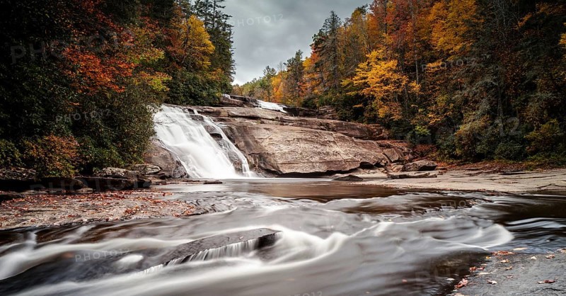 Triple Falls waterfall in fall color forest in the Appalachian mountains of North Carolina