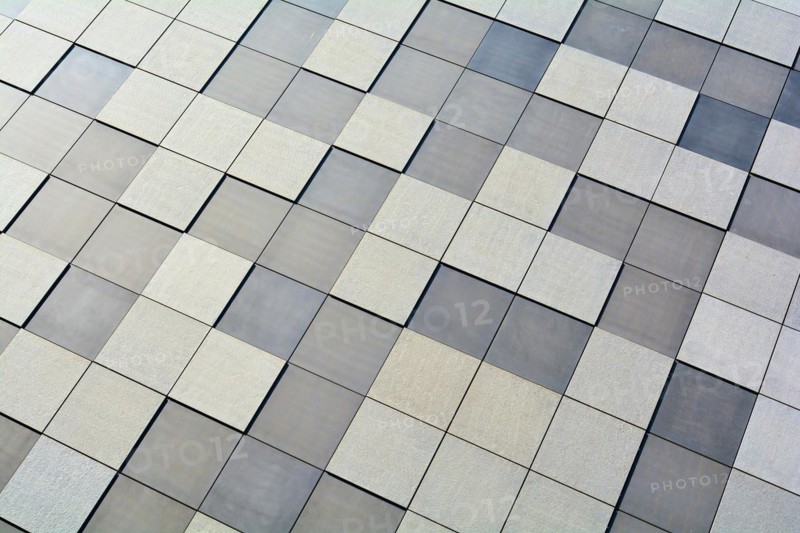 Detail of the façade of a modern building in Magdeburg. The façade is clad with square stone slabs in a chequerboard pattern