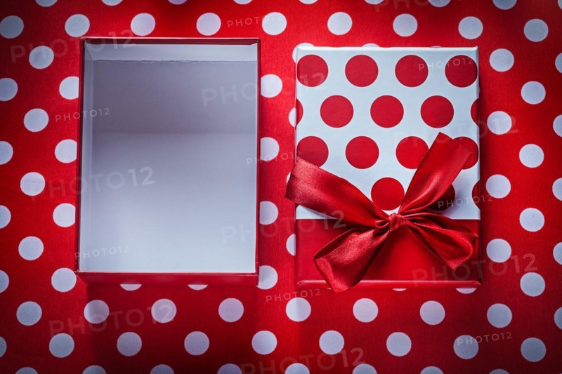 Opened present box on polka-dot red fabric celebrations concept