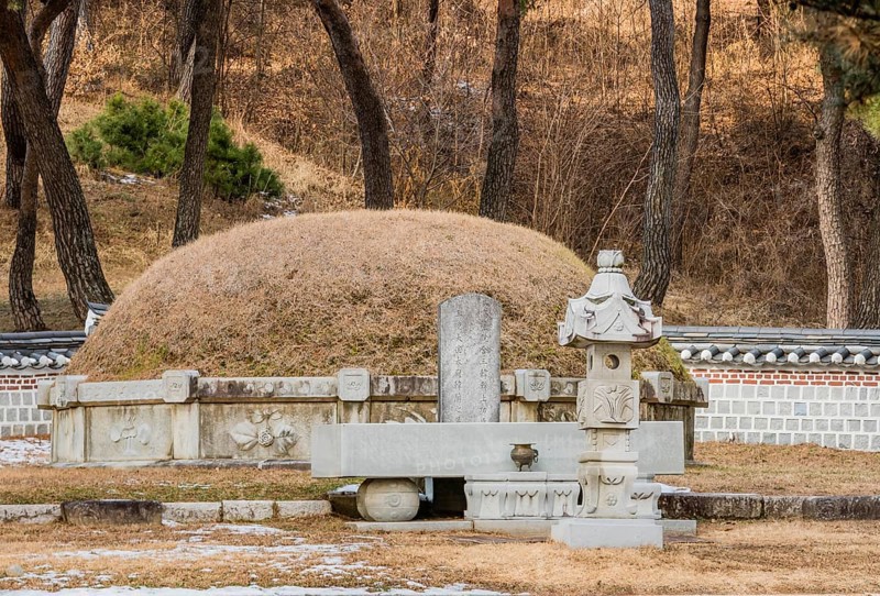 Chungju, South Korea, December 18, 2018: Burial mound surrounded by concrete wall and small statues