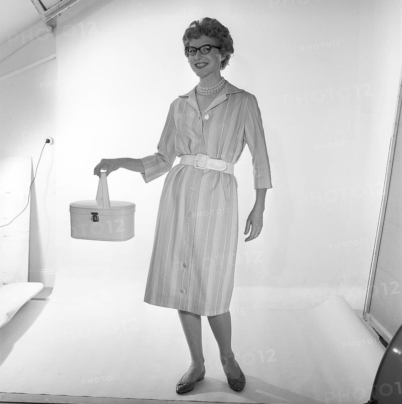 In the 1950s. A woman is pictured in the photographers studio wearing a dress and holding a handbag. Sweden 1959 Kristoffersson ref CF54-1