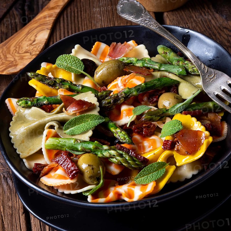 Pasta salad with green asparagus, olives and Parma ham