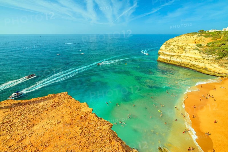 Aerial view of golden cliffs of Praia de Benagil in Algarve near Lagoa, Portugal, Europe. Boat trips to visit the famous landmark Algar de Benagil, the cave near Benagil Beach. Tourism in Algarve, Lagoa, Portogallo