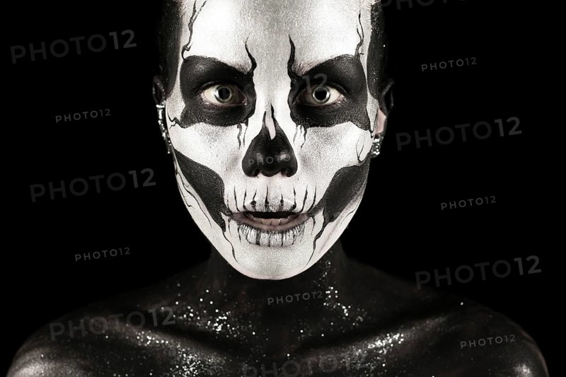 Isolated on black, closeup picture, beautiful young blonde caucasian woman with scull body art, grey eyes, penetrating look