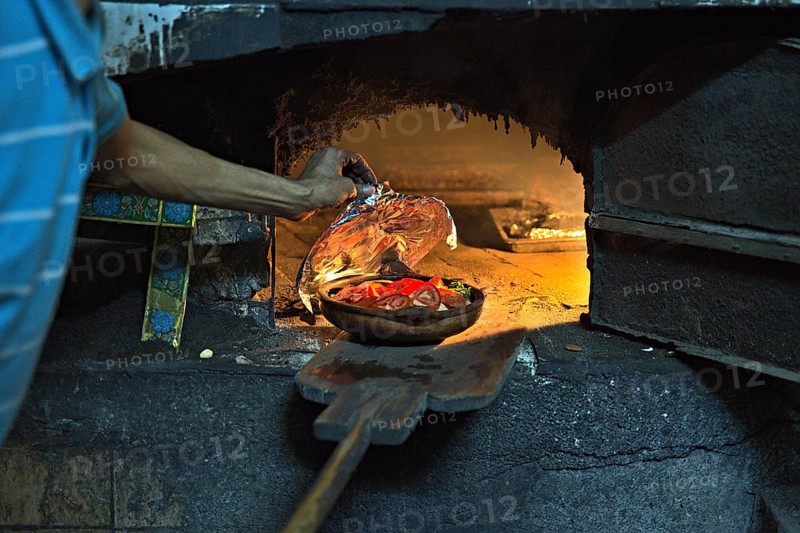 A community oven in the town of Tanger, which is used by a local and who is preparing some meal