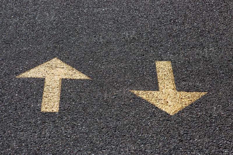 Yellow arrows on the asphalt road, back and forth