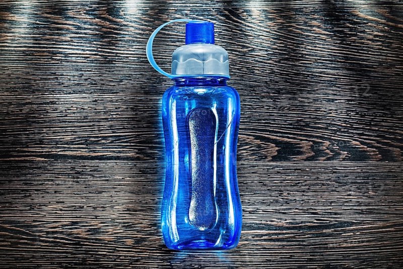 Plastic water shaker on vintage wooden board