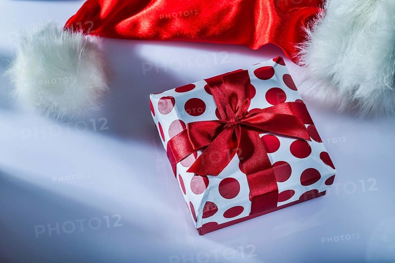 Santa cap wrapped gift box on white surface