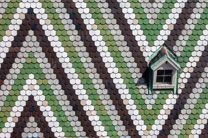 Austria, Vienna, roof of St. Stephen's Cathedral (Stephansdom), glazed tiles with pattern and small window, architectural details