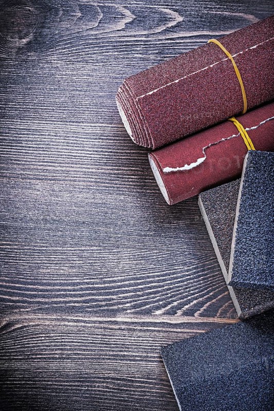 Rough abrasive paper sponges on vintage wood board construction concept