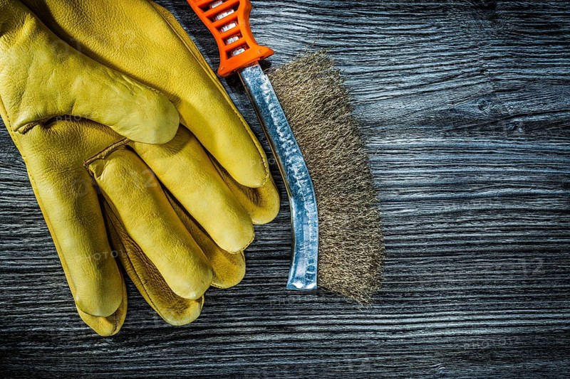 Wire brush safety gloves on vintage wooden board