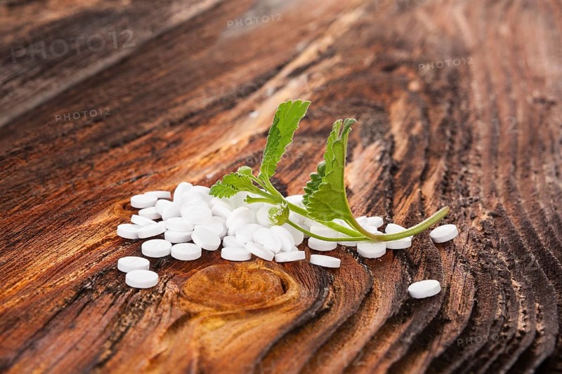 Artificial sweetener pills with aztec sweet herb on wooden table